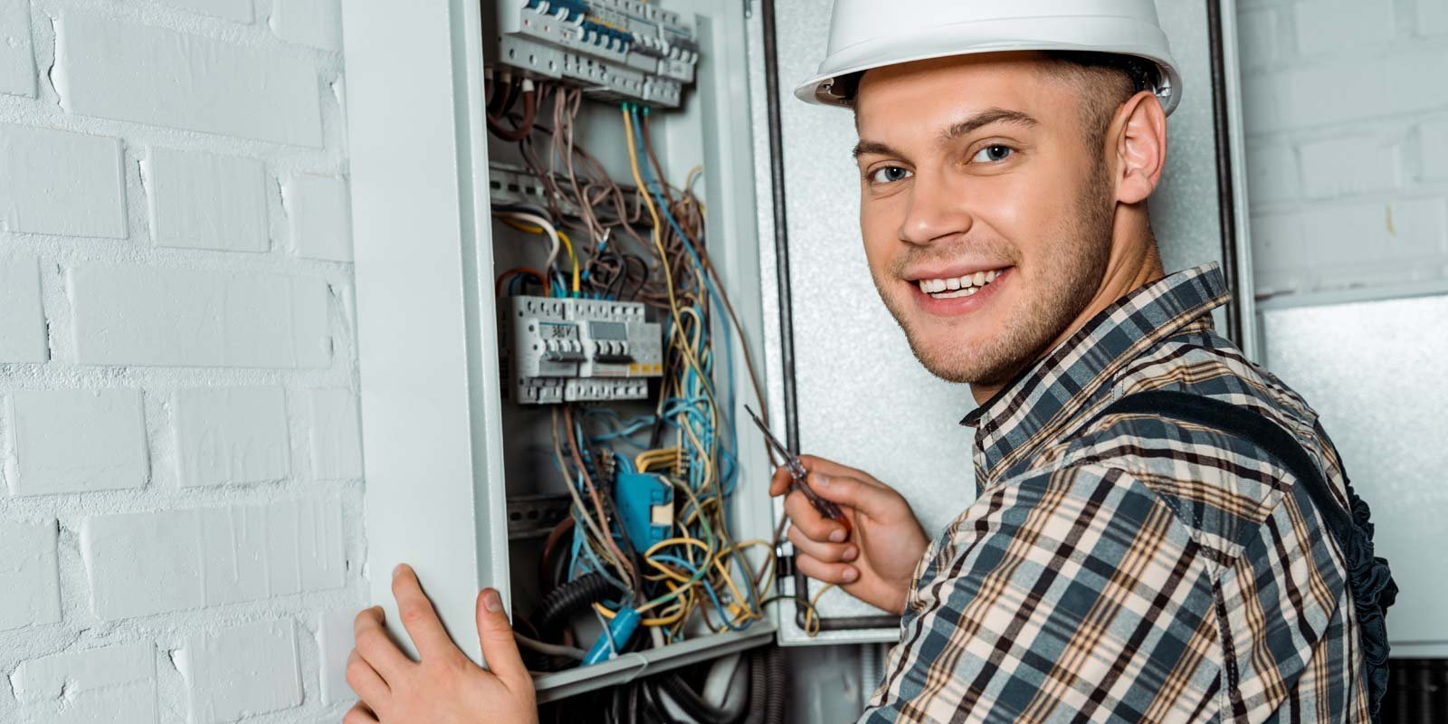 EIn Elektroniker der an einem Verteilerkasten arbeitet